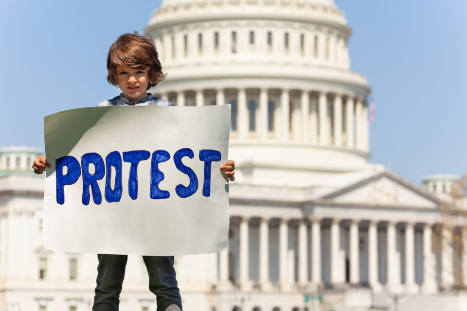 мальчик с плакатом на фоне Белого Дома